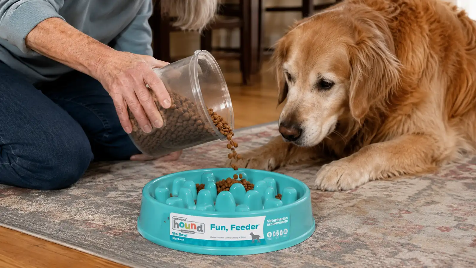 Hand pouring kibble into the ridged maze pattern of a turquoise slow feeder bowl